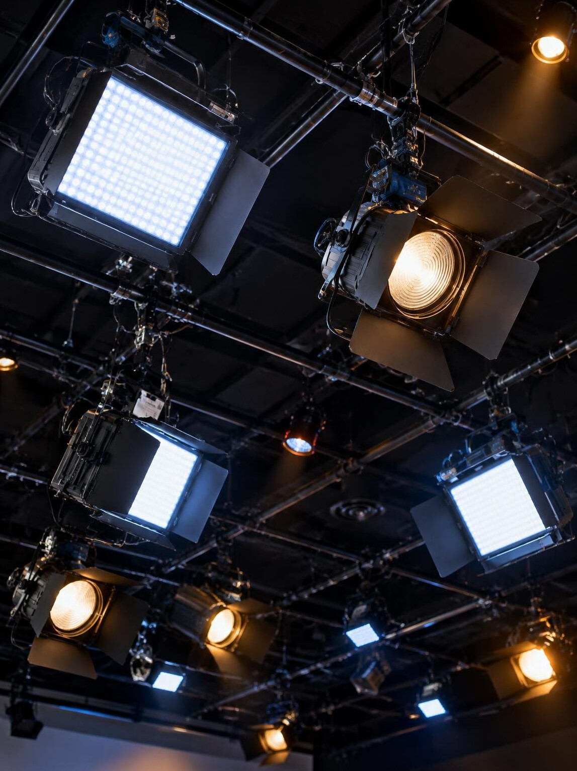 Studio lighting grid with LED panels and fresnel lamps
